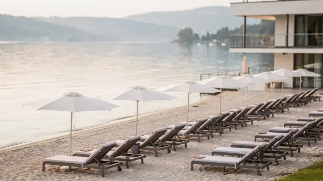 Hotel am Bodensee mit Strandbereich für Gäste und Liegestühlen am Seeufer