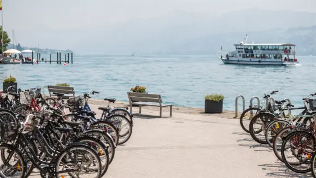 Menschenlose Uferpromenade am Bodensee mit Fahrrädern und Fähre zur Hauptsaison