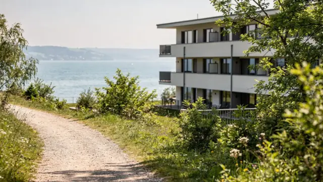 Hotel am Bodensee nahe einem Wanderweg mit See, Grün und Fußpfad