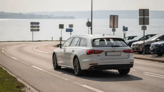 Auto auf einer Uferstraße am Bodensee mit Parkplätzen und Schildern zur Anreise mit dem Auto